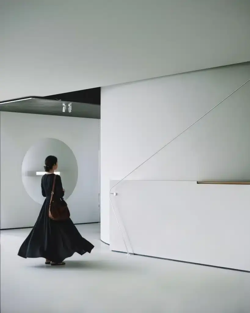 Woman walking through a minimalist and modern office reception area in Hong Kong